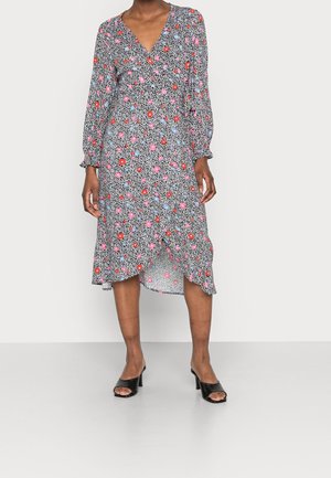 Vestido floral con base negra y flores coloridas en rosa, rojo y azul, escote en V, mangas largas y dobladillo asimétrico.