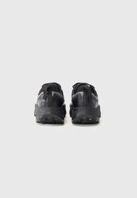 Black athletic shoes featuring a textured mesh upper, reinforced heel, and rubber sole with a gripping tread pattern.