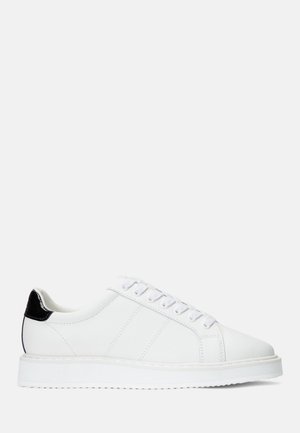 Hvid lavsko sneaker med snørebånd foran, tyk sål og sort hælaccents, vist i sideprofil på en ensfarvet baggrund.