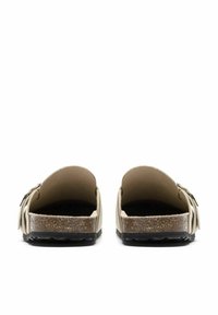 Calzature, design aperto sul retro, tomaia in pelle beige con suola in sughero strutturato, suola esterna in gomma nera, con dettagli decorativi sui lati.