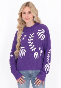 Violetti neulepaita, jossa on valkoista kukka-embroiderya, pyöreä p�ääntie, rento istuvuus ja pitkät hihat, joissa on pidennetyt hihansuut.
