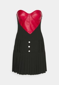Μαύρο πλισέ φόρεμα με στενή μαύρη κορσέ και κόκκινο δερμάτινο επικάλυμμα σε σχήμα καρδιάς. Διαθέτει τρία ασημένια κουμπιά στη μέση.