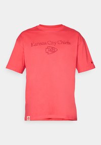 Koralfarvet kortærmet t-shirt lavet af bomuld, med broderet tekst og logo "Kansas City Chiefs" i centrum foran.
