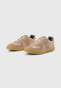 Sneaker in suede beige chiaro e mesh, con dettagli testurizzati, lacci piatti e suole in gomma color sabbia. Design a punta arrotondata.