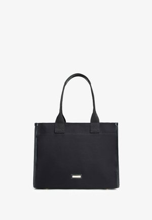 Bolsa tote rectangular negra con dos asas y pequeña etiqueta metálica de la marca centrada en la parte inferior frontal.