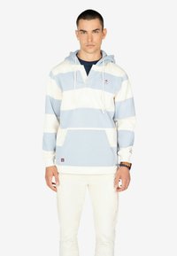 Lichtblauwe en witte gestreepte hoodie met een voorzak, witte trekkoorden en een klein embleem op de borst.