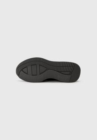 Semelle de chaussure en caoutchouc noir avec un motif de treads texturé et des rainures. Fini lisse avec une forme arrondie, adapté à divers styles de chaussures.