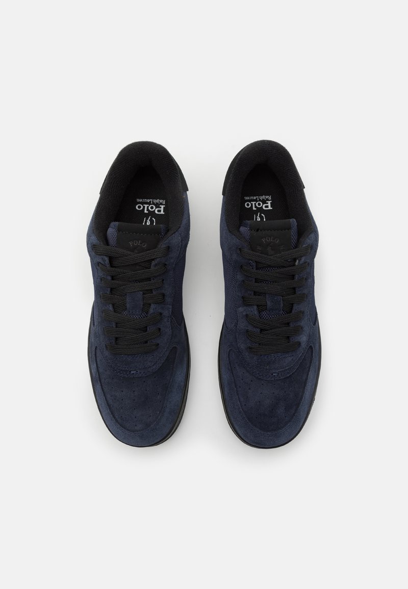 Granatowe zamszowe sneakersy z czarnymi siateczkowymi akcentami. Okrągły czubek, płaskie sznurowadła i gumowa podeszwa z wentylacyjnymi otworami oraz logo na języku.