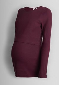 Burgundijas krāsas garām piedurknēm paredzēts grūtniecības tops, ribota tekstūra, apaļa apkakle, atbrīvota piegriezuma, ar slāņotu dizainu, lai pielāgotos augošai vēderiņai.