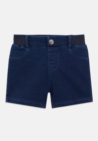 Τζιν σορτς σε σκούρο ναυτικό μπλε χρώμα, με ριμπ ύφασμα στη μέση και μεταλλικό κουμπί στο μπροστινό μέρος. Περιλαμβάνει δύο τσέπες στο μπροστινό μέρος.