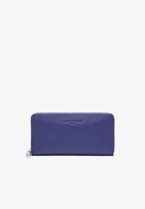 Portefeuille en cuir violet avec une texture lisse, fermeture éclair et logo en relief. Forme rectangulaire avec des bords cousus et quincaillerie en métal.