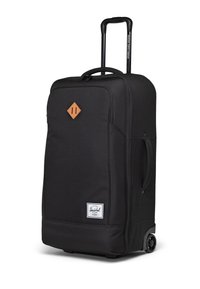 Černý kufr na kolečkách vyrobený z odolné tkaniny, s obdélníkovým tvarem, strukturovaným povrchem a koženými akcenty včetně diamantové nášivky.