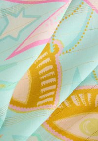 Textília s pastelovým modrým pozadím, na ktorej sú veľké žlté a ružové motýľové tvary, biele hviezdy a tenké zlaté diagonálne čiary.