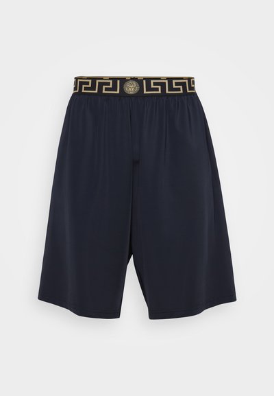 Marineblå shorts i lett materiale med elastisk midjebånd, dekorert med et gull geometrisk mønster og en løvemedaljong.