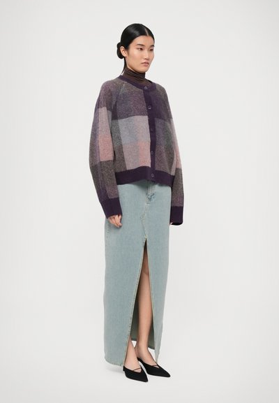 Knitted cardigan in purple and gray check pattern, paired with a light blue denim skirt featuring a front slit, and black pointed flats.