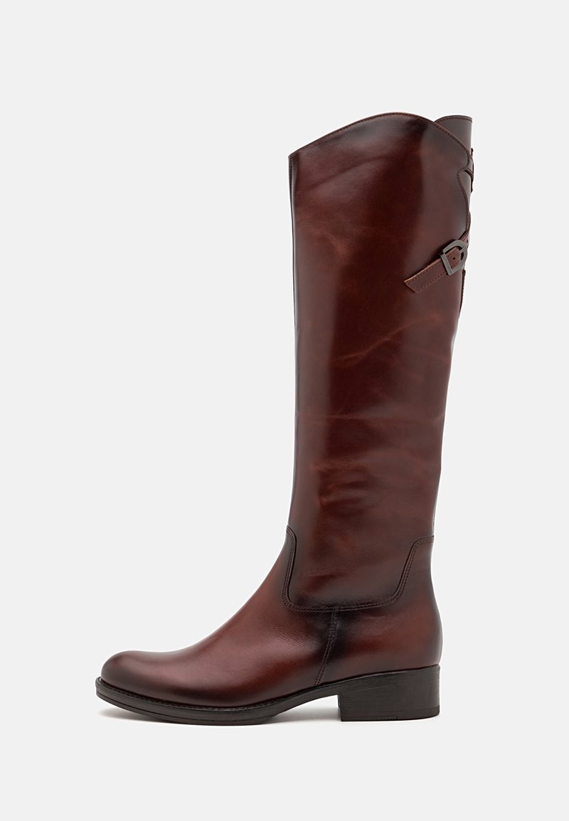 Botas de cuero marrón hasta la rodilla con una parte superior curvada y un pequeño acento de correa. Textura suave y un tacón bajo de bloque.