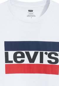Camiseta blanca de Levi's con un logotipo en negrita en negro, enmarcado por un rectángulo azul marino arriba y un rectángulo rojo abajo del texto.