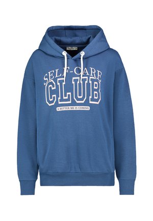 Blaues Kapuzen-Sweatshirt mit weißen Kordeln, auf der Vorderseite mit dem Schriftzug "SELF-CARE CLUB" und darunter kleinerem Text "A BETTER ME IS COMING".
