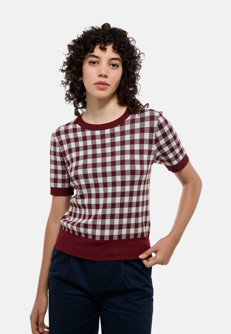 T-shirt à manches courtes et col rond, en motif à carreaux bordeaux et blanc, avec une coupe ajustée et un ourlet et des poignets bordeaux unis.
