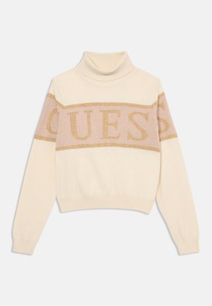 Maglione a collo alto crema con un design corto, caratterizzato da un logo "GUESS" in glitter dorato orizzontale sullo petto e polsini a coste.