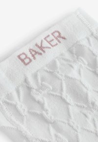 Calze bianche lavorate a maglia con un motivo a rombi testurizzato, dotate di un morbido polsino intrecciato impresso con la parola "BAKER" in cuciture rosa chiaro.