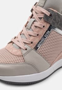 Baskets Michael Kors avec mesh rose, panneaux en cuir beige, lacets roses et détail métallique de marque sur le côté.