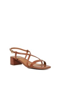 Sandale en cuir marron avec plusieurs fines lanières, un dos fermé et un petit talon bloc à texture bois.
