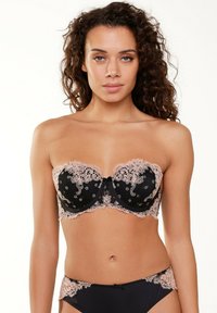 Zwarte strapless beha met beige kantafwerking, voorzien van bloemmotieven en een strikdetail in het midden. Gladde stof, contrasterende kleuren.