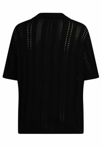 Camisa negra de gran tamaño con mangas cortas, que presenta un diseño de tejido abierto con patrones de rayas verticales y un cuello clásico. Tela texturizada.