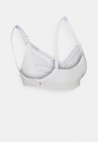 Bralette blanc en tissu doux, avec des bretelles réglables, une texture lisse et une fermeture à crochets dans le dos.