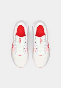 Zapatillas deportivas blancas con detalles rojos; parte superior de malla, cordones con detalles reflectantes, interior acolchado y suela texturizada.