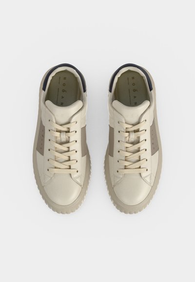 Paire de baskets en cuir beige et taupe avec lacets et panneaux latéraux marqués, vue de dessus sur fond blanc.