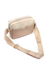 Béžová crossbody taška s hladkým vrchem a texturovaným dnem. Obsahuje zipovou přihrádku a nastavitelný popruh. Velmi odolný polyesterový materiál.