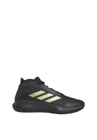 Chaussure de sport montante noire avec logo trois bandes dorées sur le côté et semelle texturée, conçue pour le sport ou un usage décontracté.