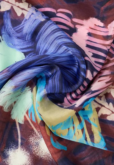 Πολύχρωμο ύφασμα με αφηρημένα λουλουδάτα σχέδια σε μπλε, ροζ, κίτρινο και τυρκουάζ, απαλά στριμμένο για να δείξει την υφή και τη ροή.