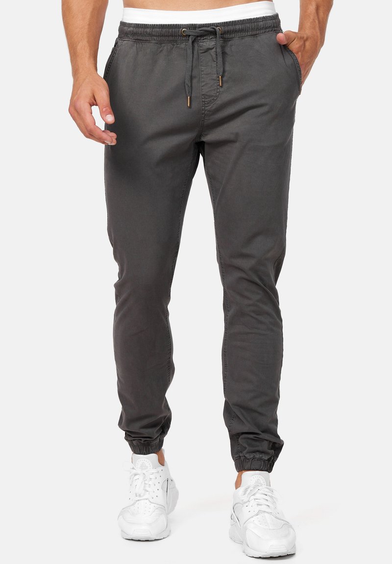 Pantalones de chándal grises de tejido ligero, con puños elásticos, cintura ajustable con cordón y bolsillos laterales para almacenamiento.