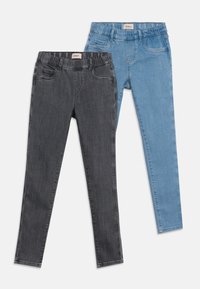 Δύο ζευγάρια στενών τζιν με ελαστικές μέσες, ένα σε σκούρο γκρι και ένα σε ανοιχτό μπλε τζιν, τοποθετημένα επίπεδα σε λευκό φόντο.