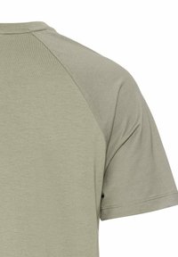 Olivengrøn kortærmet t-shirt med en glat struktur og rund halsudskæring, der har en sømdetalje ved skulderovergangen.