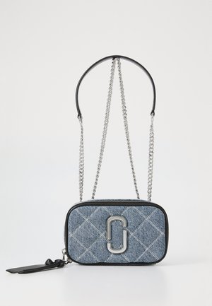 Bolsa transversal em denim com um padrão matelassé, detalhes em couro preto, alça de corrente prateada e um destacado logotipo na frente.