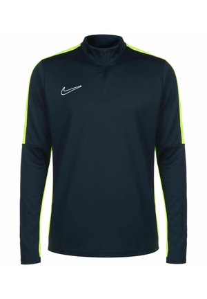 Marineblauw sportieve top met lange mouwen en een kwart-rits kraag, neon groene zijpanelen en wit geborduurd logo op de borst. Gladde, lichte stof.