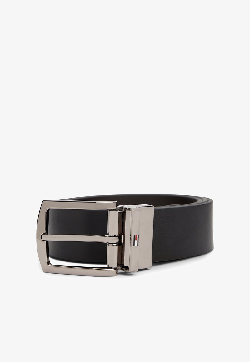 Ceinture en cuir noire avec boucle métallique rectangulaire argentée présentant un petit logo rouge, blanc et bleu sur la boucle.