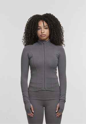 Szara, sportowa kurtka na zamek z długim rękawem, wysokim kołnierzem, dopasowanym fasonem i otworami na kciuki w mankietach; gładka, elastyczna tkanina.