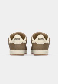 Brown suede sneakers with a cream-colored rubber sole and accents. Features a prominent FILA logo at the heel and a cushioned collar.