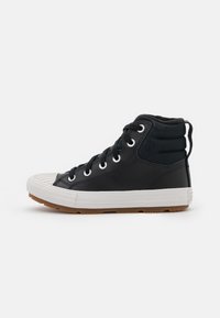 Sneaker alte nere realizzate in pelle e tela, con punta in gomma bianca, lacci rotondi e suola in gomma marrone.