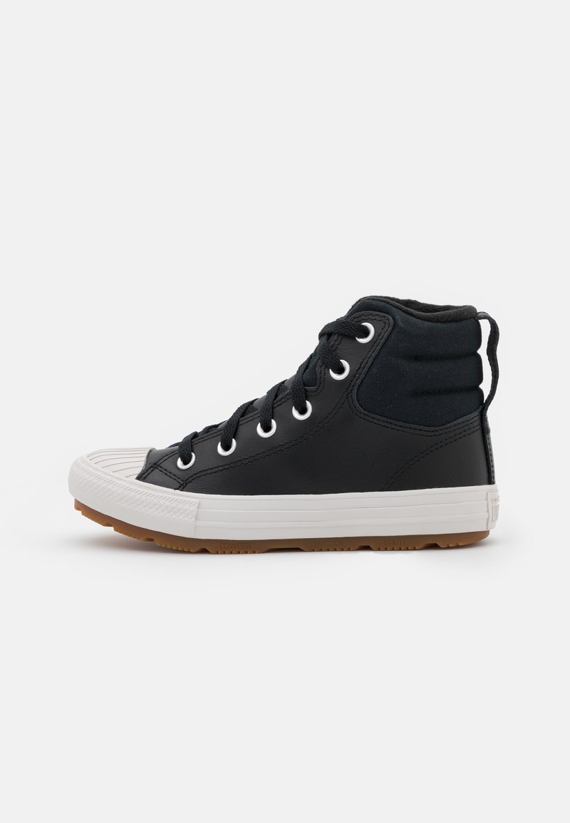 Sneaker alte nere realizzate in pelle e tela, con punta in gomma bianca, lacci rotondi e suola in gomma marrone.