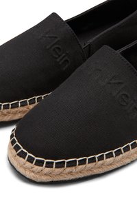 Espadrillas nere in tela con punta arrotondata, caratterizzate da un logo in rilievo ben visibile e da un dettagli di corda di juta a contrasto lungo la suola.