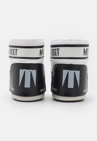 Para czarnych i białych butów narciarskich Moon Boot widocznych od tyłu z logo i grubą podeszwą na białym tle.