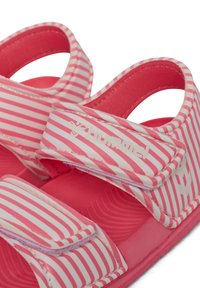 Rosa und weiß gestreifte Sandalen mit verstellbaren Klettverschlüssen und einer strukturierten Gummisohle, die ein gepolstertes Innenleben für zusätzlichen Komfort bieten.