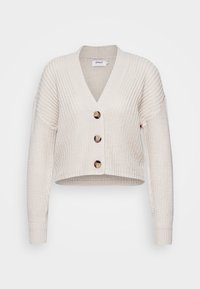 Ljust beige stickad kofta med V-ringning, långa ärmar och fyra knappar framtill. Texturerad ribbad tyg med en kortare design.