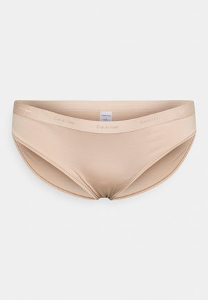 Boxer bege sem costura com uma textura suave e lisa. Apresenta um logótipo da Calvin Klein na cintura. Projetado para conforto e mínima visibilidade.